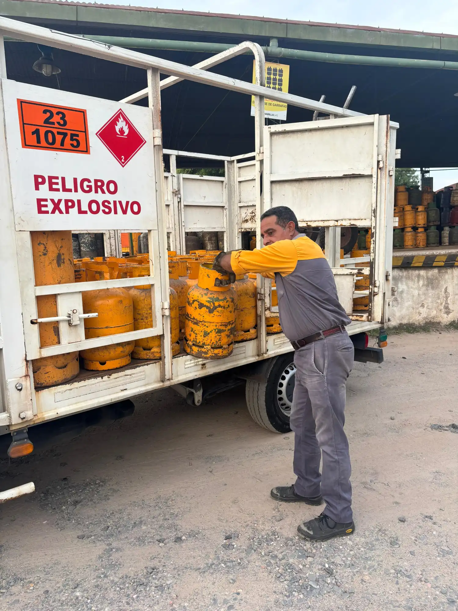 Empleado cargando una garrafa en el camion de distribución.