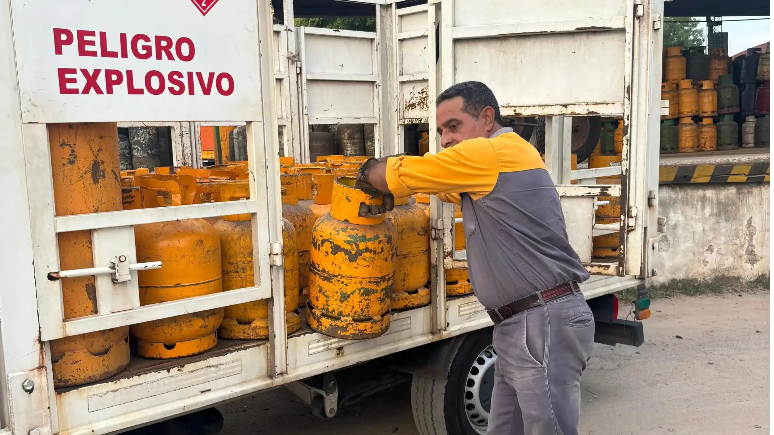 Empleado cargando una garrafa en el camion de distribución.